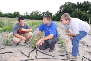 Ft White High School student Noah Meyers (left) and  Christopher Glenn (right) take instruction from Extension Agent Mace Bauer as Agri-Science Teacher Wayne Oelfke  instructs students in the back of the field at Ft White High Schools Agri-Science demonstration gardens.Careers opportunities for students in agriculture vary in marketing, biology, chemistry and computer systems. Credit: Jen Chasteen. 